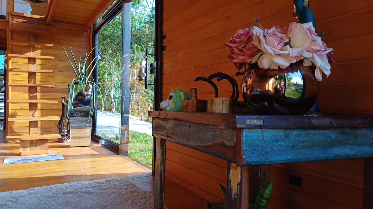Canto de estar da cabana com flores e janela panorâmica